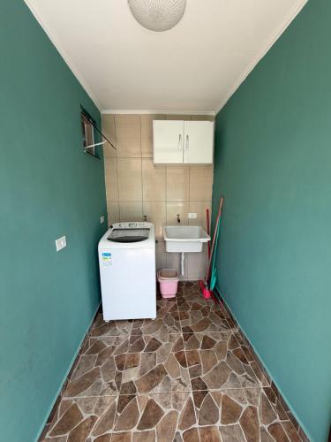 a small kitchen with a sink and a washer and dryer at Casa em Ipanema - Pontal do Paraná in Pontal do Paraná