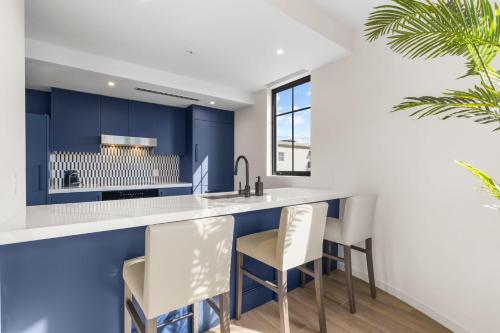 a kitchen with blue cabinets and white countertops at The Avenue Hotel Coral Gables in Miami