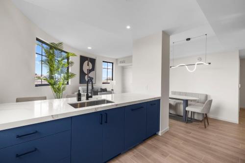 a kitchen with blue cabinets and a white counter top at The Avenue Coral Gables in Miami