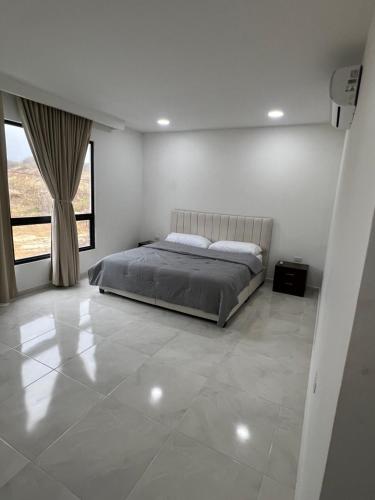 a bedroom with a bed and a large window at Villa Sabanilla Casa bifamiliar campestre con piscina privada Aire acondicionado Tranquilidad total in Puerto Colombia
