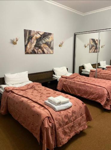 ein Zimmer mit zwei Betten mit roter Bettwäsche und einem Spiegel in der Unterkunft MonaLisa in Kharkov