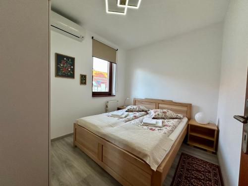 a bedroom with a bed and a window at Germar Apartman in Pécs