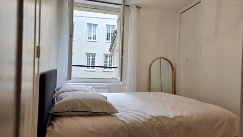 a bedroom with a large bed and a window at Le Saint Jacques - Downtown in Melun