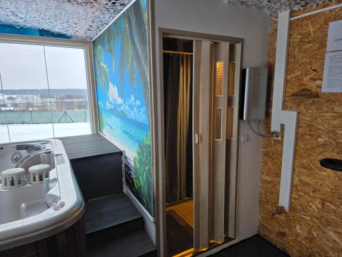 a bathroom with a sink and a tub and a window at Domki Rekreacyjne "Błękitne Wzgórze" in Żałe