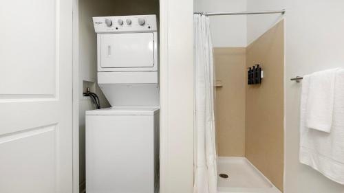 a washer and dryer in a bathroom with a shower at Landing Apartments - Prospect Hall in Frederick