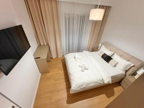 a small bedroom with a bed with white sheets and pillows at La felix bulevard in Biharia