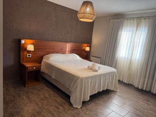 a bedroom with a bed and a table and a lamp at Las Cabras Complejo Turístico in Potrero de los Funes