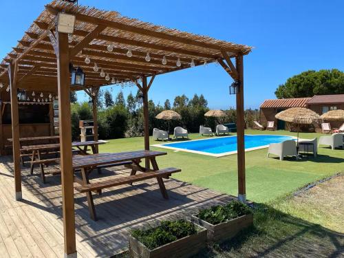 a wooden pavilion with a picnic table and a pool at Country Spot - Summer House in Porto Covo