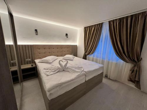 a small bedroom with a bed and a window at Green Wood in Azuga