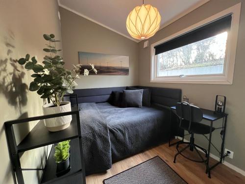a bedroom with a bed and a table with a potted plant at The Fäxaåsen cabin in Varberg
