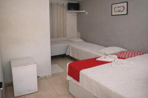 a room with two beds and a trash can at Mutary II in Santa Cruz Cabrália