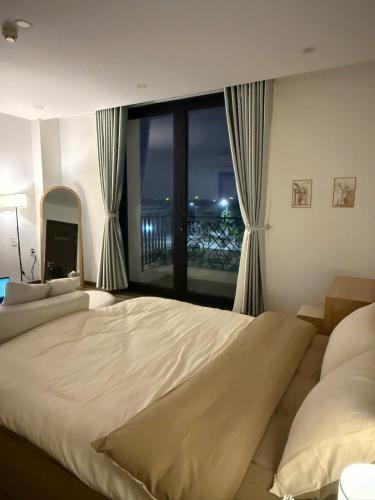 a bedroom with a large bed and a large window at LucyHouse in Thôn Trường Giang