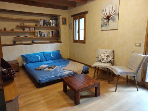 a room with a bed and a table and chairs at La Casetta Vacanze in Molini di Triora
