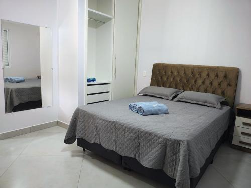 a bedroom with a large bed and a mirror at Casas Bela Vista 1 - 2 in Águas de Lindoia