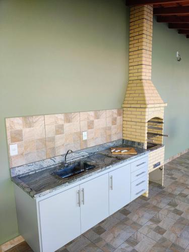 a kitchen with a sink and a brick oven at Casas Bela Vista 1 - 2 in Águas de Lindoia