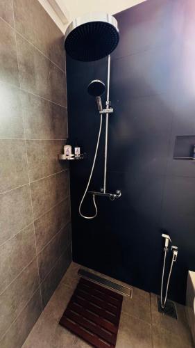a shower in a bathroom with a black wall at Humble Ella in Ella