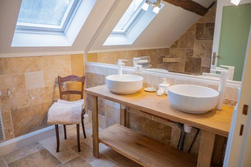 a bathroom with two sinks on a wooden counter at La Suite de Richarville in Richarville