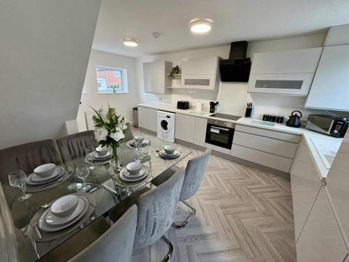 a dining room table with chairs and a kitchen at The Sherwood Snug in Edwinstowe