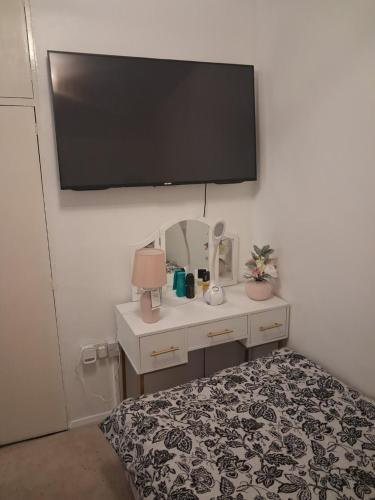 a bedroom with a bed and a tv on the wall at Cullen Sqaure in South Ockendon