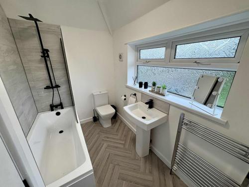 a bathroom with a tub and a sink and a toilet at The Sherwood Snug in Edwinstowe