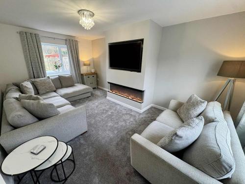 a living room with two couches and a fireplace at The Sherwood Snug in Edwinstowe