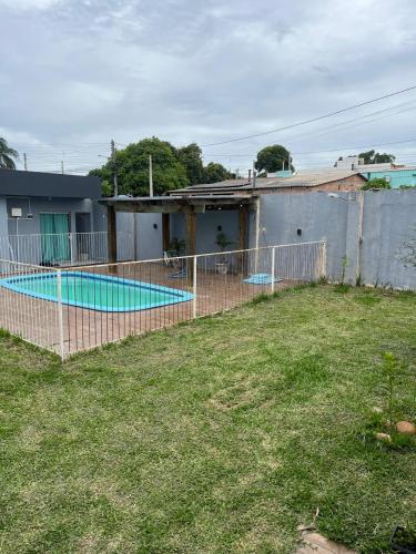 a fence around a swimming pool in a yard at Casa Gui in São Gabriel