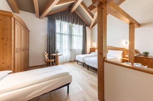 a bedroom with two beds and a large window at WHITE MOSS GARNì in Transacqua