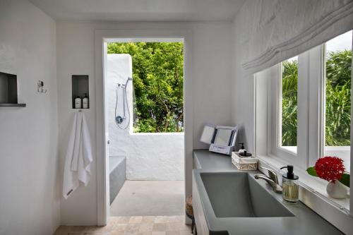 un bagno con lavandino, vasca e finestra di Villa Santorini a Enighed