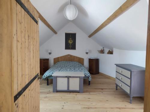 a bedroom with a bed and a dresser at Le refuge in Montabon