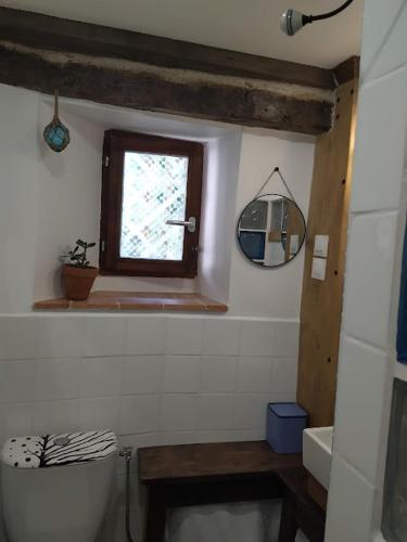 a bathroom with a window and a sink and a toilet at Le refuge in Montabon