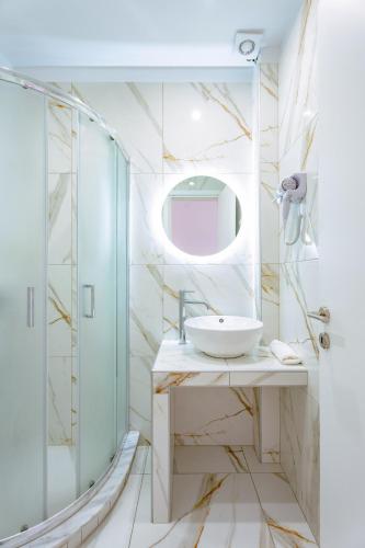 un bagno con lavandino e doccia di Sirens Resort a Áyioi Apóstoloi