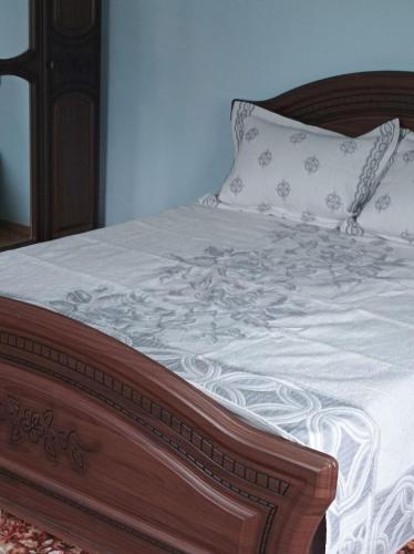 a bed with a wooden frame and a pillow on it at Ольга in Ogrody