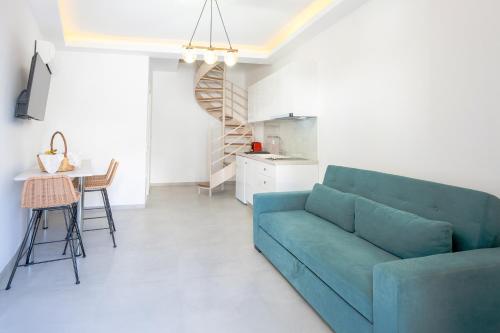 un soggiorno con un divano blu e un tavolo di Sirens Resort a Áyioi Apóstoloi