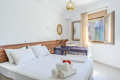 una camera da letto con un letto con asciugamani e uno specchio di Sirens Resort a Áyioi Apóstoloi