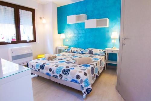 a bedroom with a bed and a blue wall at Rosemary Charming Rooms in Termoli
