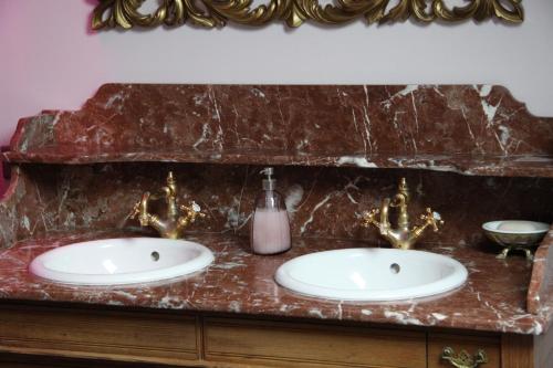 a bathroom with two sinks and a marble counter at L'Hibernie in Rochefort-en-Yvelines