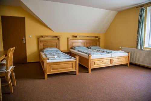 Zimmer mit 2 Betten und einem Tisch in der Unterkunft Hotel Sirákov in Liptál