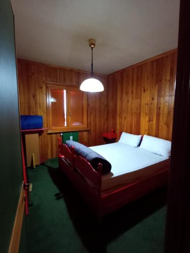 a bedroom with a bed with a couch in it at Casetta mia, Pian de Valli in Terminillo