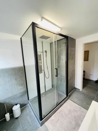 a glass shower in a bathroom with at Lichtdurchflutetes Souterrain Apartment in Schapen in Braunschweig