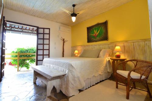 a bedroom with a bed and a table and a chair at Pousada Casa de Maria in Prado