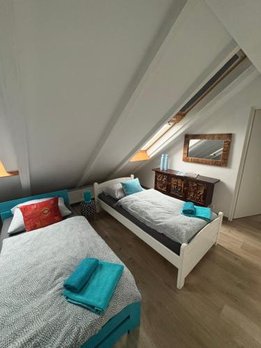 a attic bedroom with two beds and a mirror at Apartament Loft DeLuxe Koszalin in Koszalin
