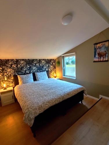 a bedroom with a large bed and a window at Morning Glory Huisje Jasmijn in Beekbergen
