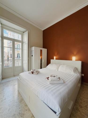 a large white bed in a room with a large window at Diaz Central Rooms in Salerno