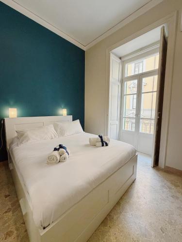 a bedroom with a large white bed with two stuffed animals on it at Diaz Central Rooms in Salerno