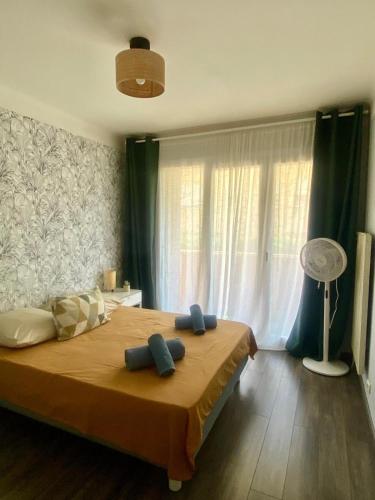 a bedroom with a large bed with blue pillows on it at Appartement T3 avec grand balcon in Le Pradet
