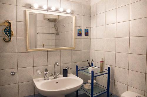 un bagno con lavandino e specchio di Casa Elena Spetses a Spetses
