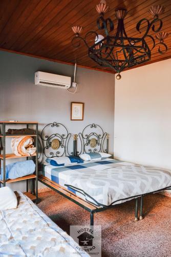 a bedroom with two beds and a wooden ceiling at HOSTEL DEL HERRERO in Apóstoles