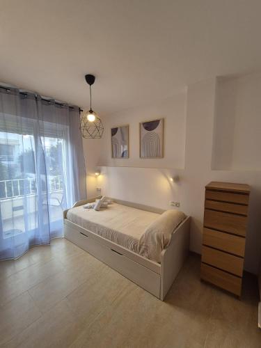 a bedroom with a bed and a dresser and a window at Apartamento Escobar Plaza in Nerja