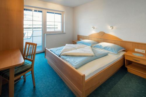 Schlafzimmer mit einem Bett, einem Schreibtisch und einem Fenster in der Unterkunft Adlerhorst Apart in Nauders