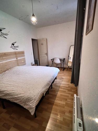 a bedroom with two beds and a table in it at La maison de Victoire in Fourmies